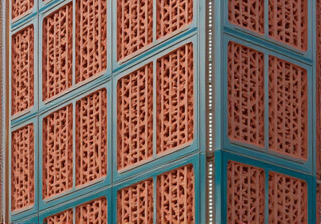 Modern community center facade featuring traditional Indian Jali patterns and terracotta finishes